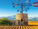 Traditionelle Windmühle aus Stein vor Bergen auf Mallorca unter klarem Himmel